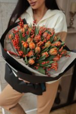 Букет з оранжевими тюльпанами та ягодами ілекса