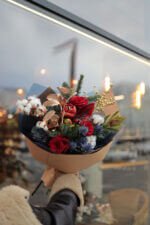 Яскравий букет з бавовни, хвої, червоних троянд та ягід